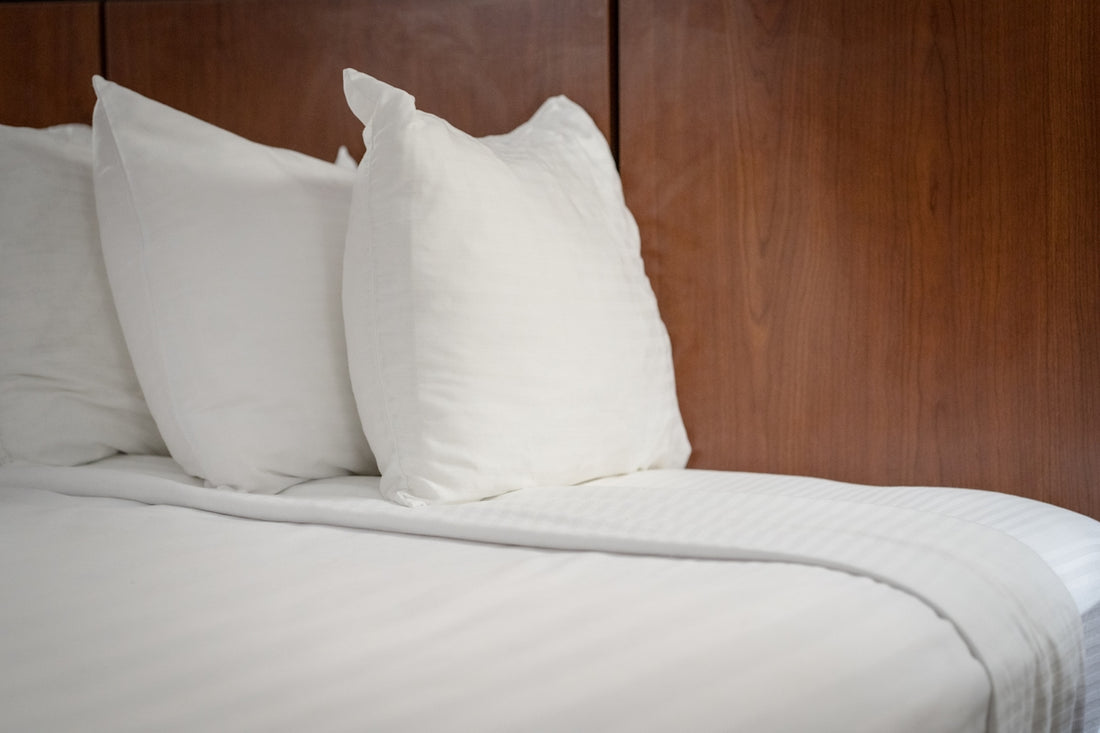a group of white pillows on a bed