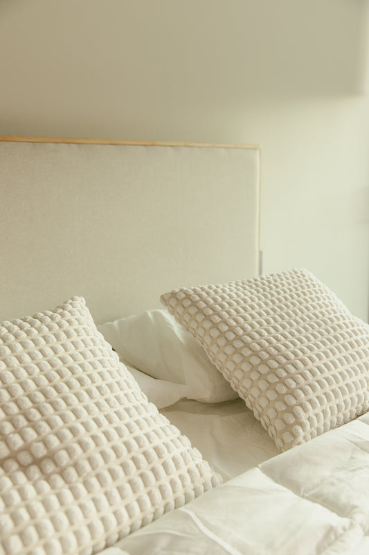 Cozy bed with pillows and soft linens.