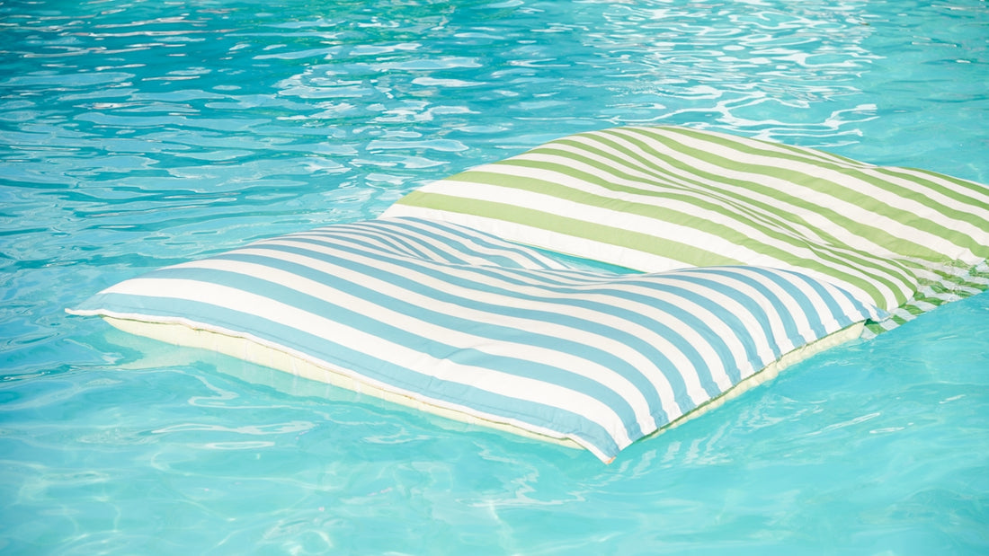 Two striped cushions floating on clear blue water